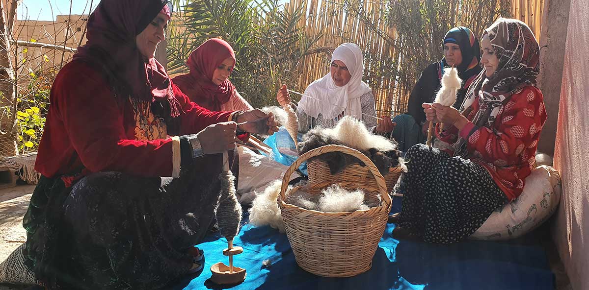 Berber women preparing wool using traditional techniques.